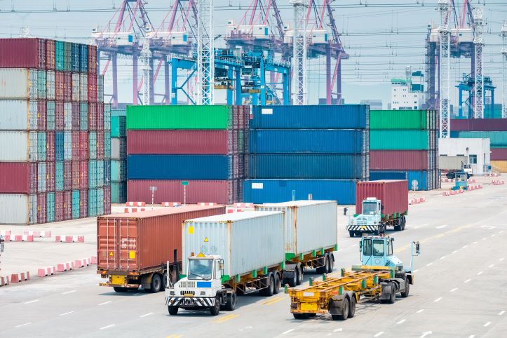Busy container port with international shipping operations Close-up view of a busy container port with stacked shipping containers used for global freight transport and logistics operations